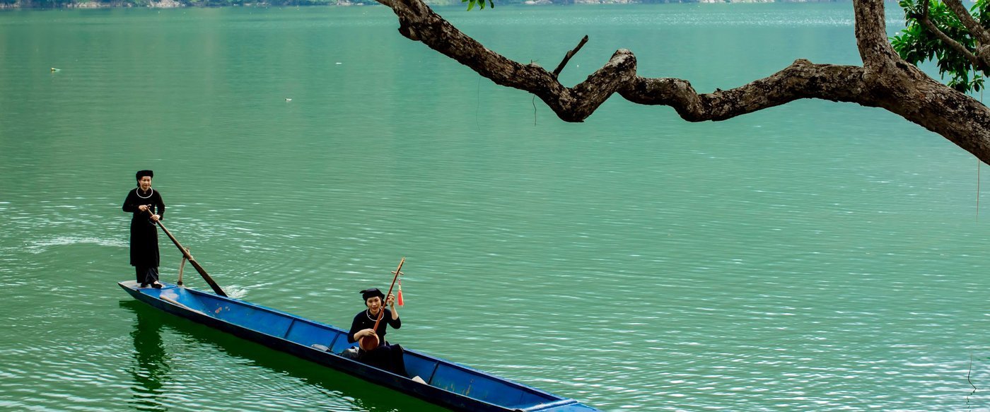 Boat beneath overhanging trees on Ba Be Lake
