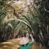 Sampan boat among water coconut palms in the Mekong Delta